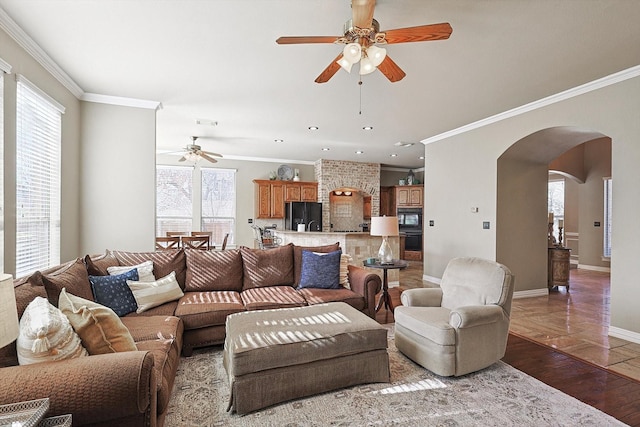 living room featuring light hardwood / wood-style floors, ceiling fan, and crown molding