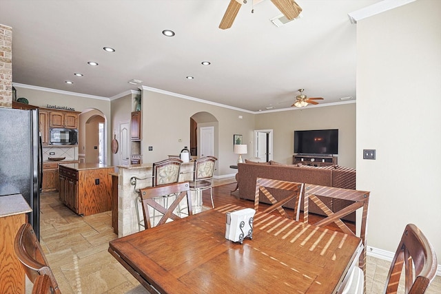 dining area featuring ceiling fan and crown molding