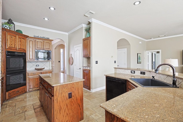 kitchen featuring black appliances, crown molding, a kitchen island, sink, and tasteful backsplash