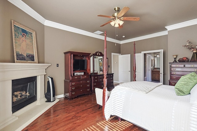 bedroom with ensuite bath, ceiling fan, crown molding, and dark wood-type flooring