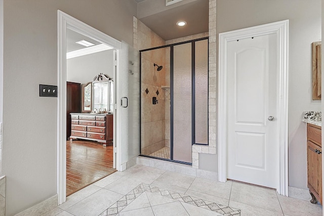 bathroom with ornamental molding, tile patterned floors, walk in shower, and vanity