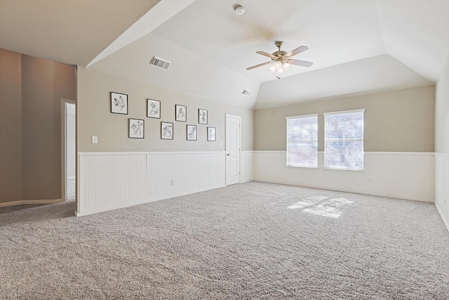 carpeted spare room featuring lofted ceiling and ceiling fan