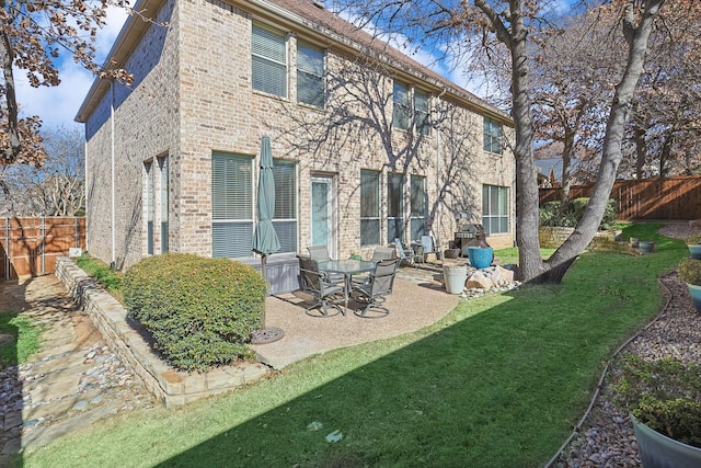 rear view of property with a lawn and a patio