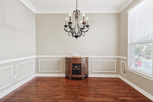 unfurnished dining area featuring ornamental molding, dark wood-type flooring, and an inviting chandelier