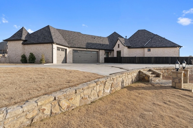 french country inspired facade featuring a front yard and a garage