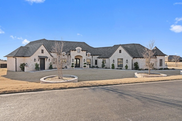 french provincial home featuring a front yard