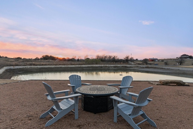 yard at dusk featuring a water view