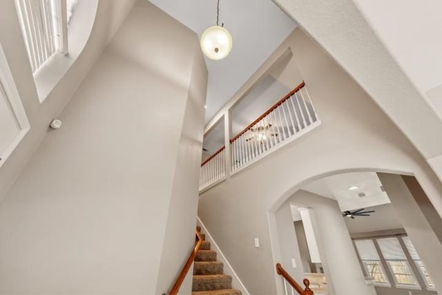 stairs with a high ceiling and ceiling fan