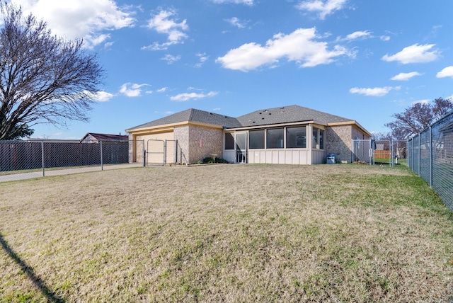 rear view of house with a yard and a sunroom