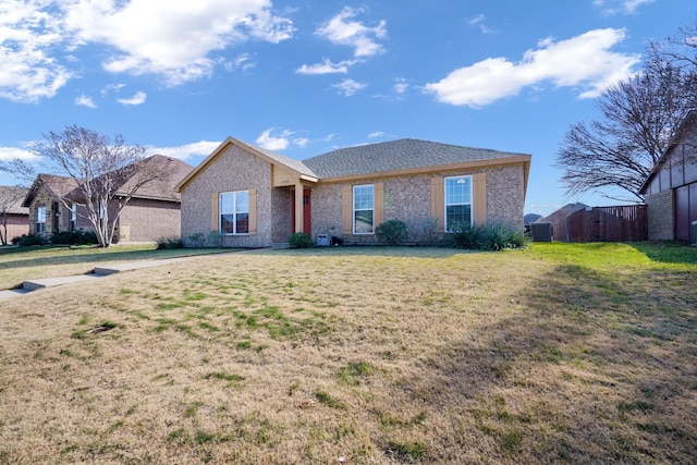 ranch-style house featuring a front yard and central AC unit