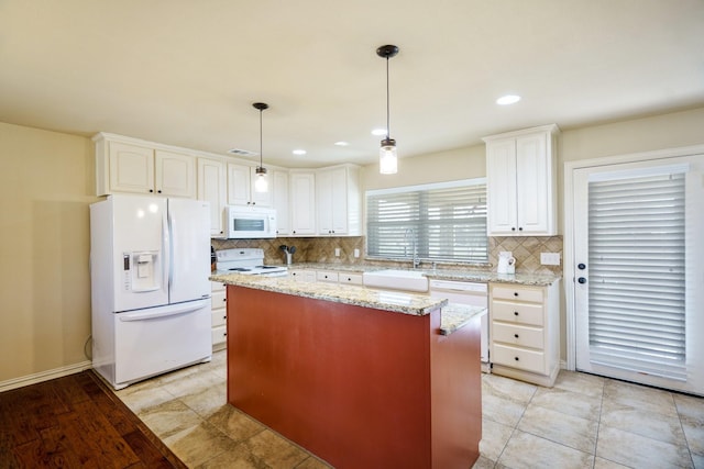 kitchen featuring a center island, sink, white cabinets, and white appliances