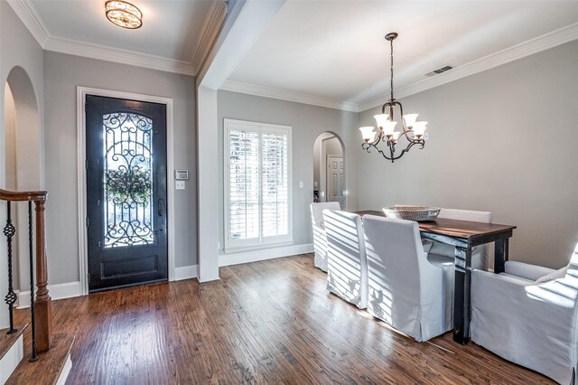 foyer featuring a notable chandelier, dark hardwood / wood-style floors, and crown molding