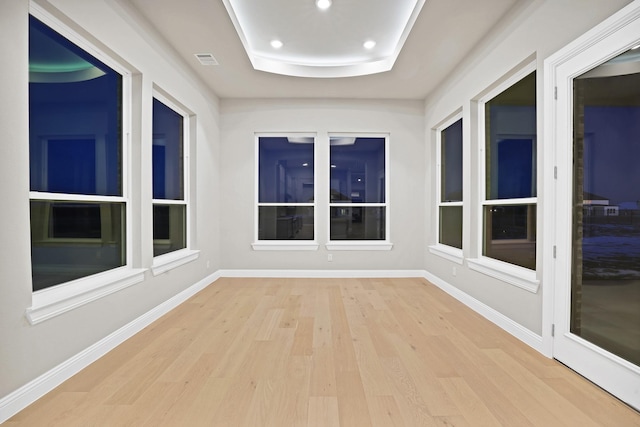 unfurnished sunroom featuring a tray ceiling