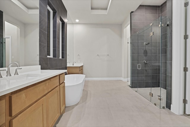 bathroom featuring vanity, plus walk in shower, and a tray ceiling