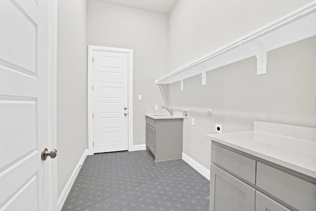 washroom with sink, cabinets, and hookup for an electric dryer