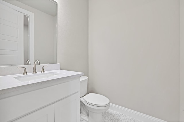 bathroom with tile patterned flooring, vanity, and toilet