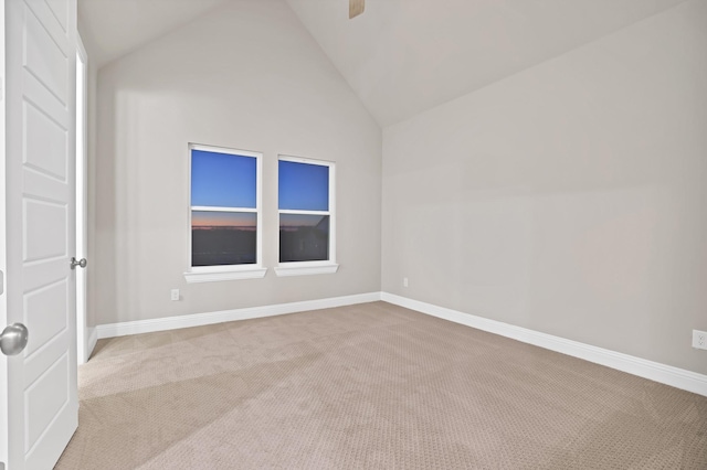 carpeted empty room with lofted ceiling