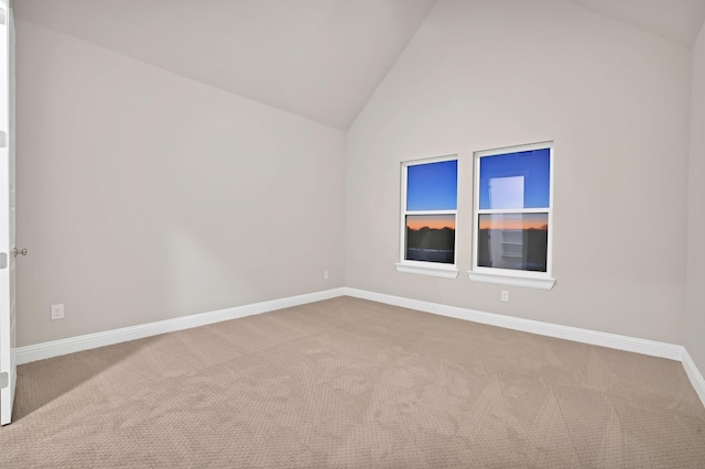 carpeted empty room with high vaulted ceiling