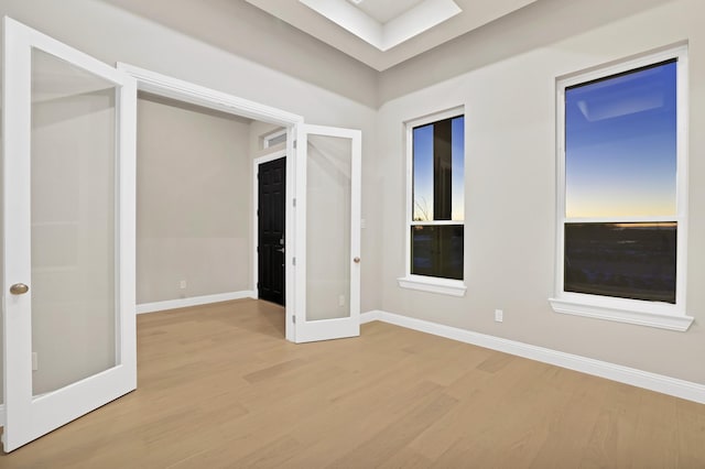 empty room featuring french doors and light wood-type flooring