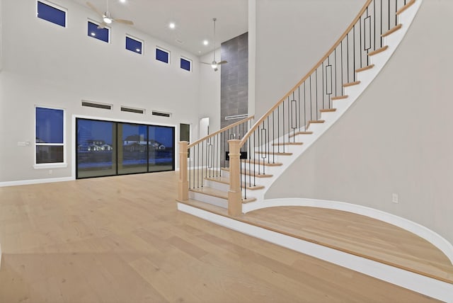 interior space with hardwood / wood-style floors, ceiling fan, and a high ceiling