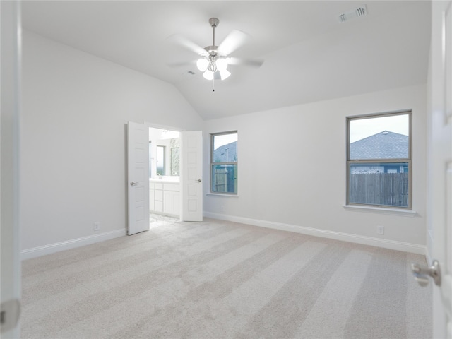 empty room featuring light carpet, vaulted ceiling, and ceiling fan