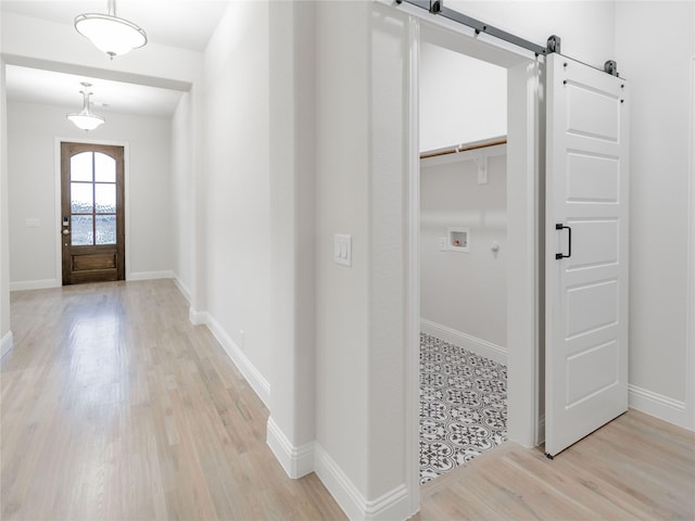 entrance foyer with a barn door and light wood-type flooring