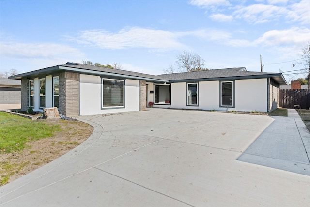 view of front of property featuring fence and brick siding