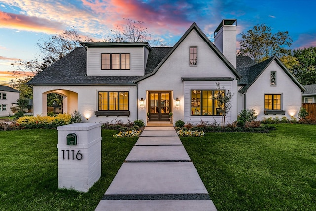 view of front of home featuring a lawn and french doors