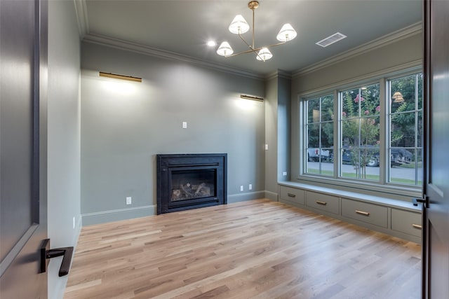 unfurnished living room with ornamental molding, a notable chandelier, and light hardwood / wood-style flooring