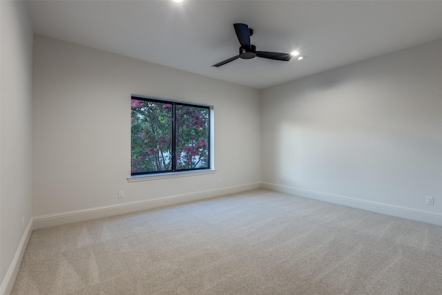 carpeted spare room featuring ceiling fan