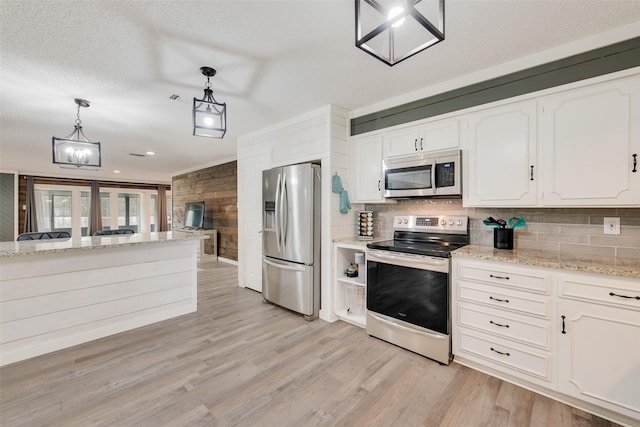 kitchen with tasteful backsplash, stainless steel appliances, decorative light fixtures, light wood-type flooring, and white cabinetry