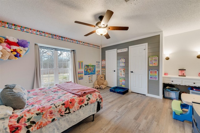 bedroom featuring a textured ceiling, ceiling fan, and light hardwood / wood-style flooring