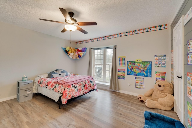 bedroom featuring ceiling fan, light wood-type flooring, and a textured ceiling