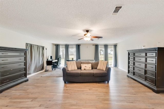 interior space featuring light wood-type flooring, a textured ceiling, and ceiling fan