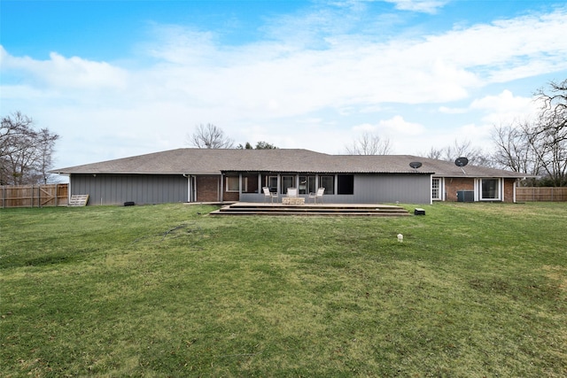 back of property with a wooden deck and a lawn