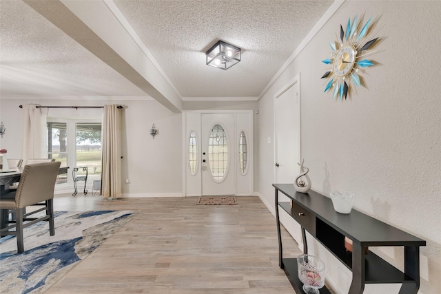 foyer entrance featuring a textured ceiling, crown molding, and wood-type flooring