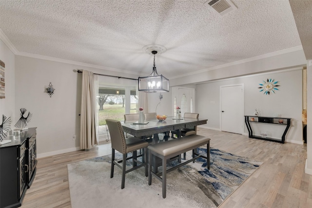 dining room featuring ornamental molding, a textured ceiling, and light hardwood / wood-style floors