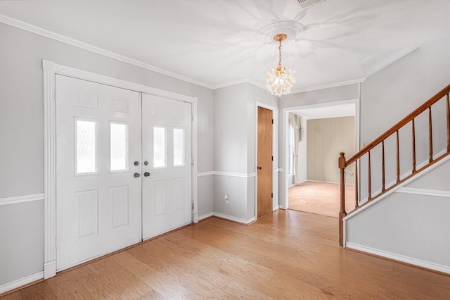 foyer featuring ornamental molding, a chandelier, and light hardwood / wood-style floors