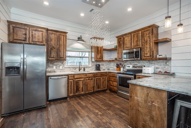 kitchen with sink, appliances with stainless steel finishes, ornamental molding, light stone countertops, and decorative light fixtures