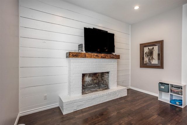 unfurnished living room with dark hardwood / wood-style floors and a brick fireplace