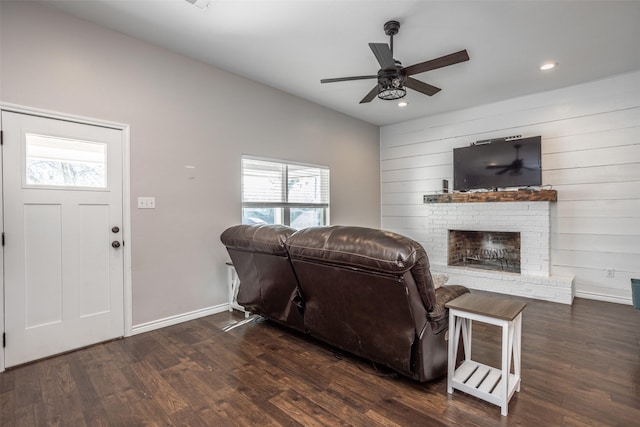 living room with ceiling fan, vaulted ceiling, dark hardwood / wood-style floors, and a fireplace