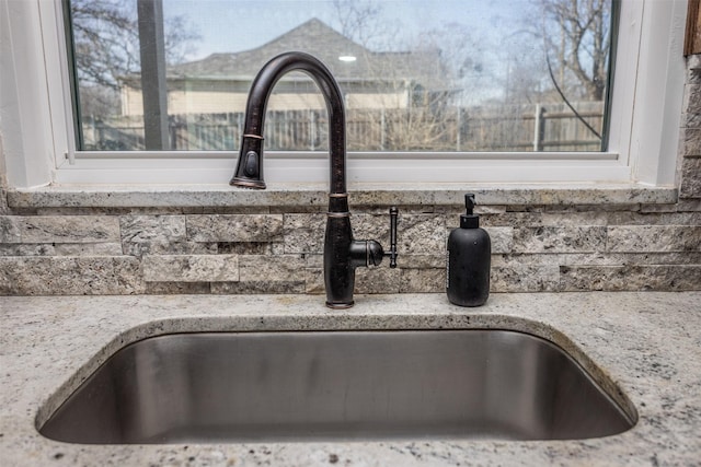 interior details featuring light stone countertops and sink