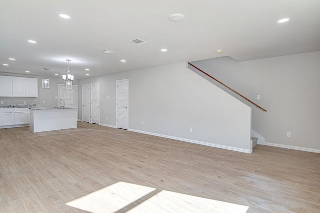 unfurnished living room featuring light hardwood / wood-style floors and sink