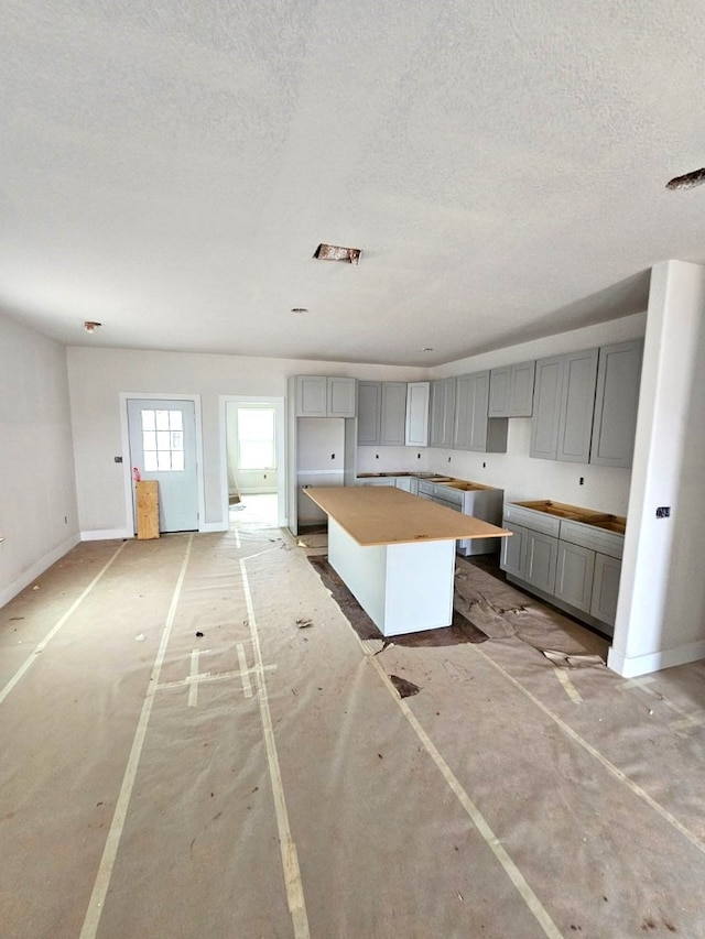 kitchen featuring gray cabinets, a kitchen island, and a textured ceiling