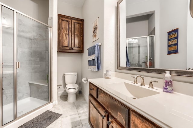 bathroom featuring toilet, a shower with door, vanity, and tile patterned floors