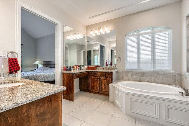 bathroom with vanity, tile patterned floors, and a tub to relax in