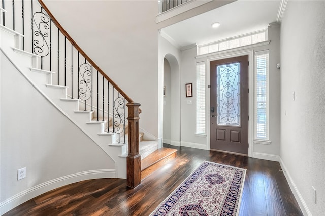 entryway with dark hardwood / wood-style flooring, ornamental molding, and plenty of natural light