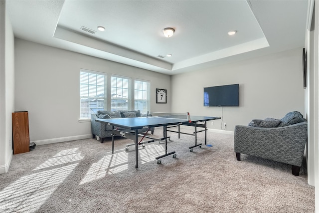 rec room featuring a tray ceiling and carpet flooring