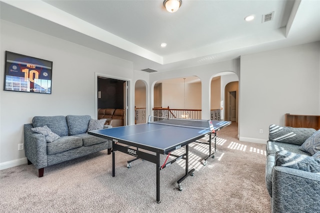 recreation room with carpet and a tray ceiling