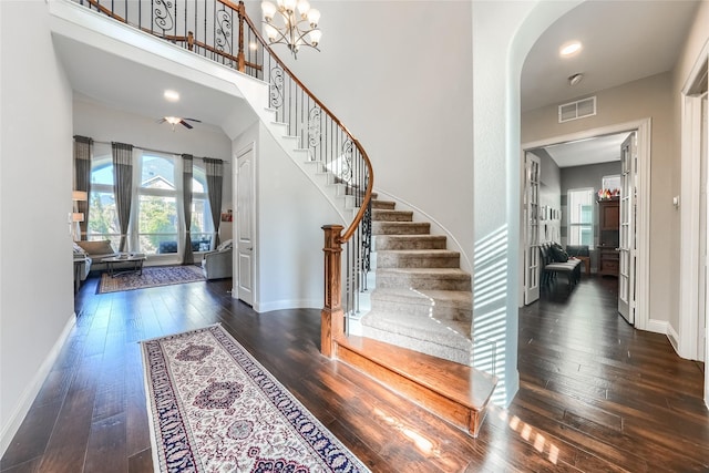 foyer entrance with dark hardwood / wood-style flooring and a notable chandelier